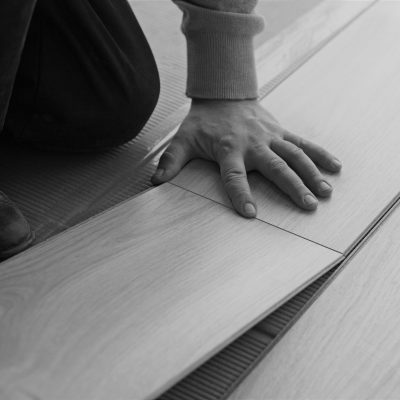 worker makes markup for laying laminate flooring